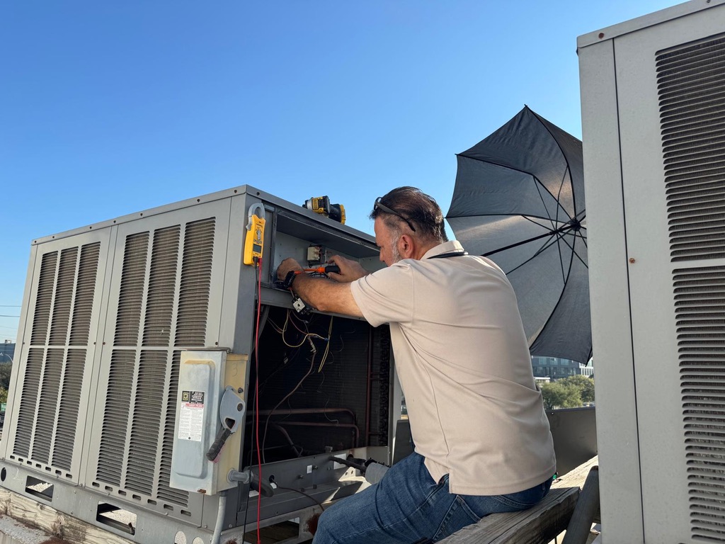 Kambiz servicing a commercial rooftop HVAC unit